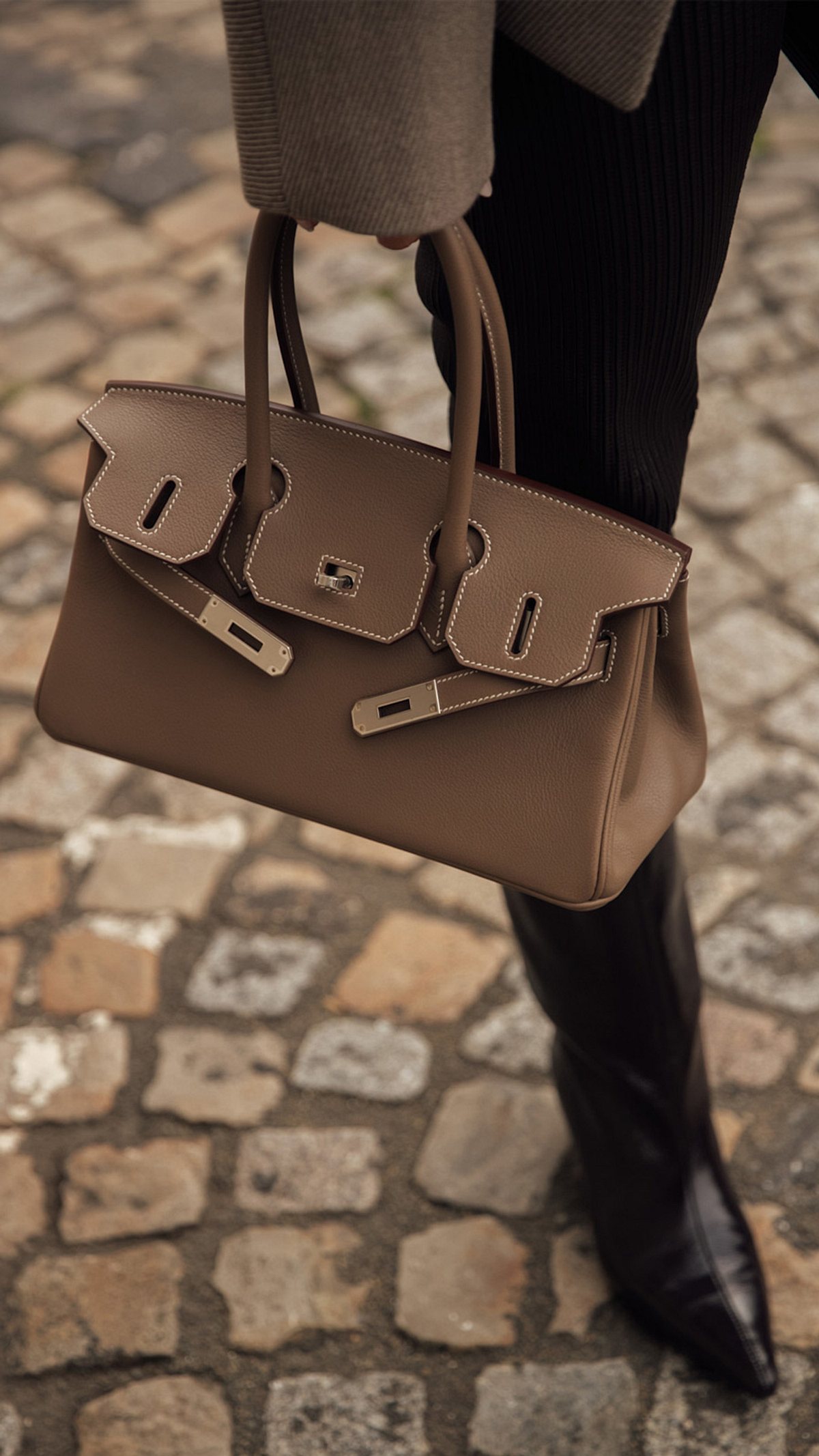 Frühjahrsmode 2025 Hand hält beige East-West-Bag von Hermés