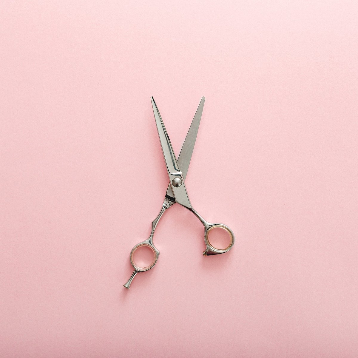 Friseurschere auf rosa Hintergrund