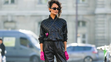 Street Style mit schwarzer Lederhose und pinken Handschuhen - Foto: Getty Images / Edward Berthelot